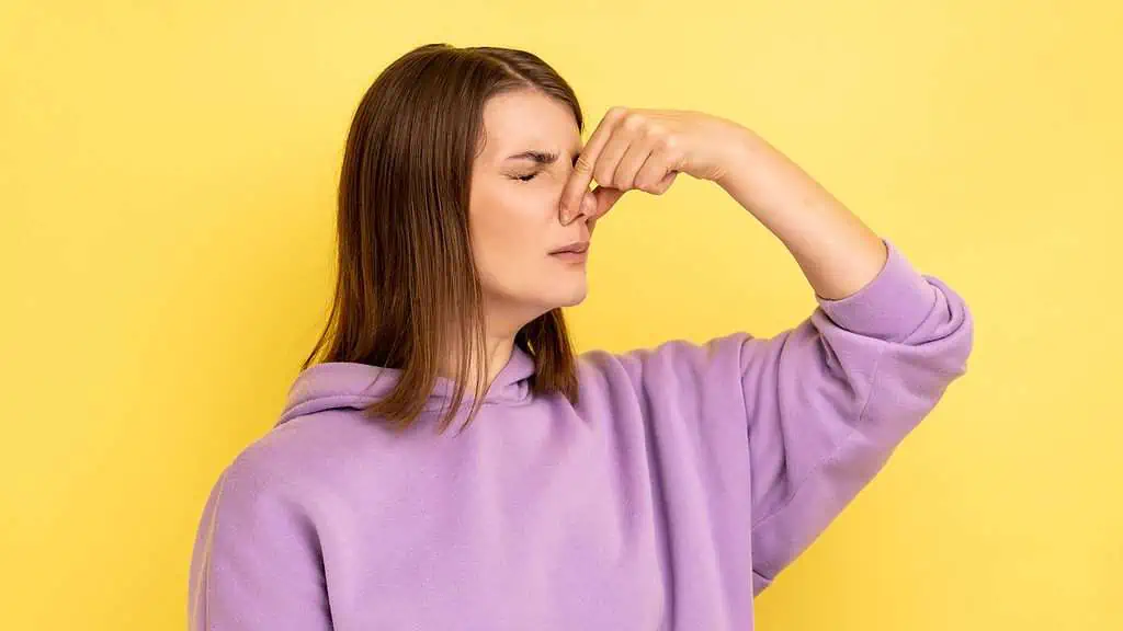 A woman smelling something bad